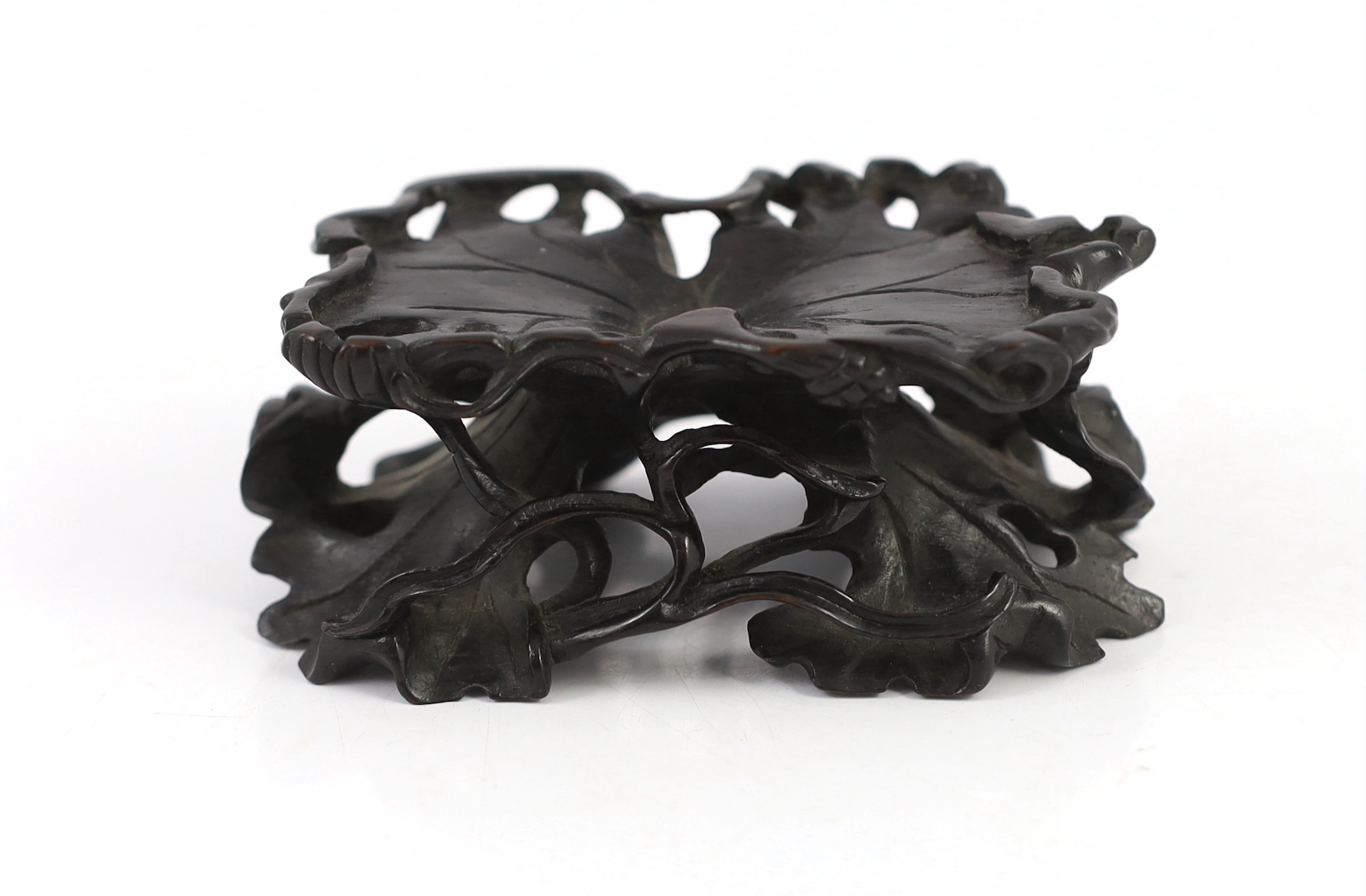 A Chinese carved wood ‘lotus’ stand and a Chinese huanghuali ‘dragon’ stand, Qing dynasty